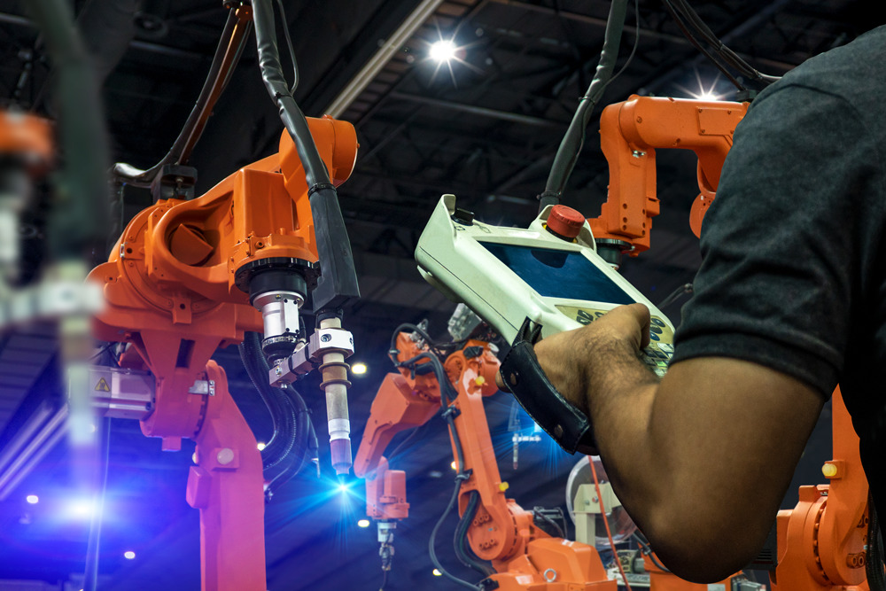 Mann steuert industrielle Roboter